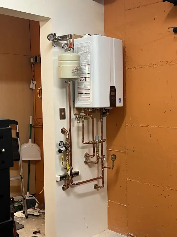 Plumbing technician inspecting water heater connections in Watchung